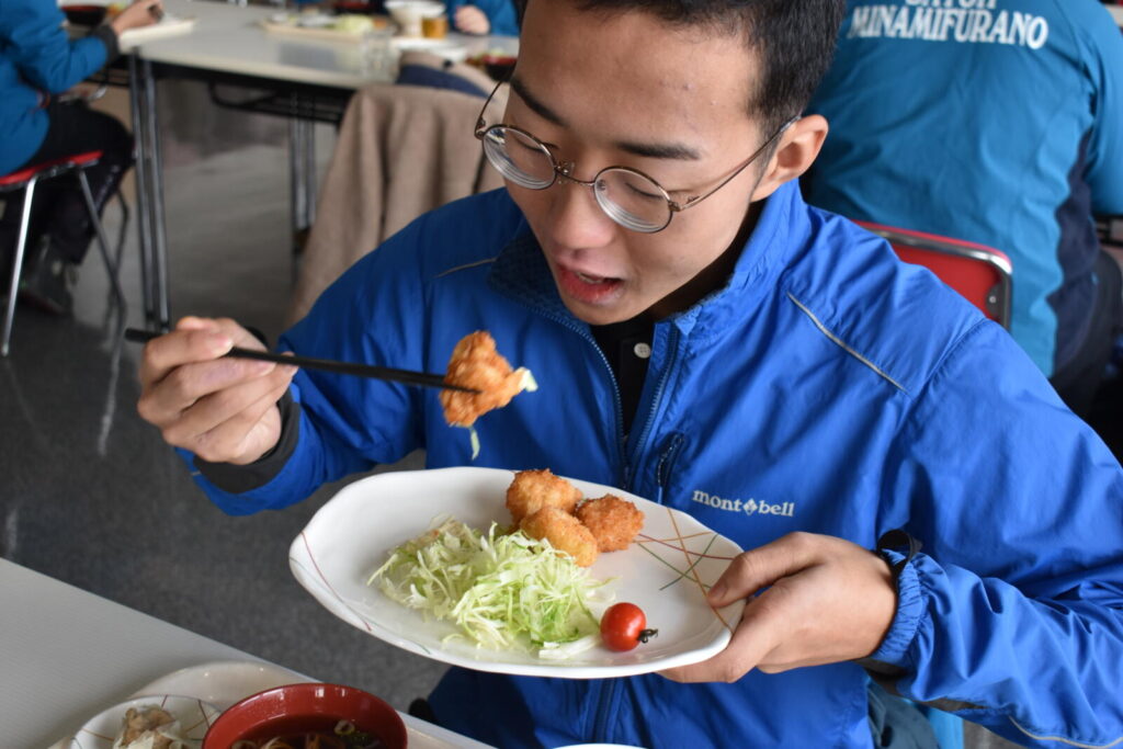 学食のホタテフライ定食をほおばる